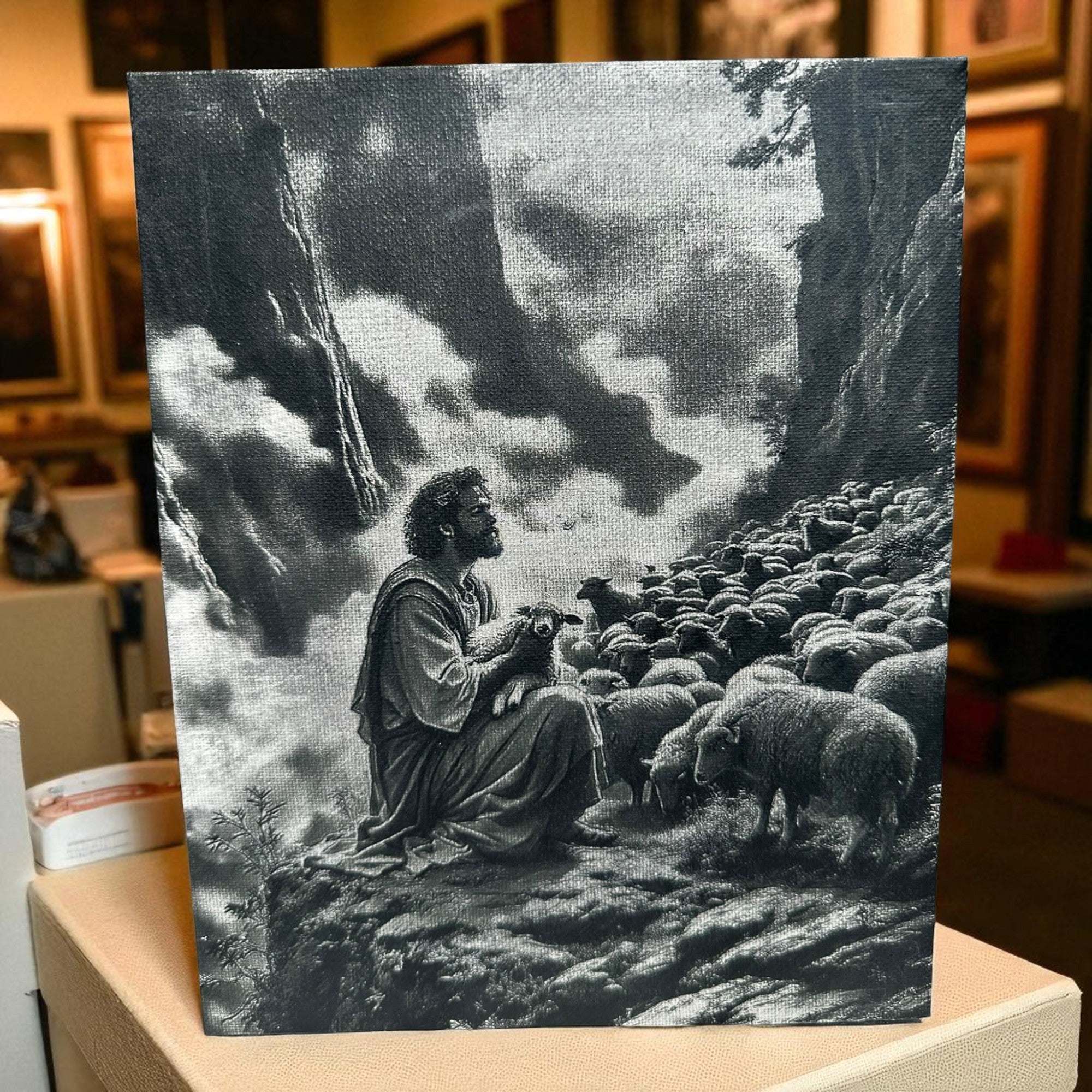 Laser-engraved 8x10 canvas art depicting the shepherd holding a lost sheep among a flock in a dramatic landscape.