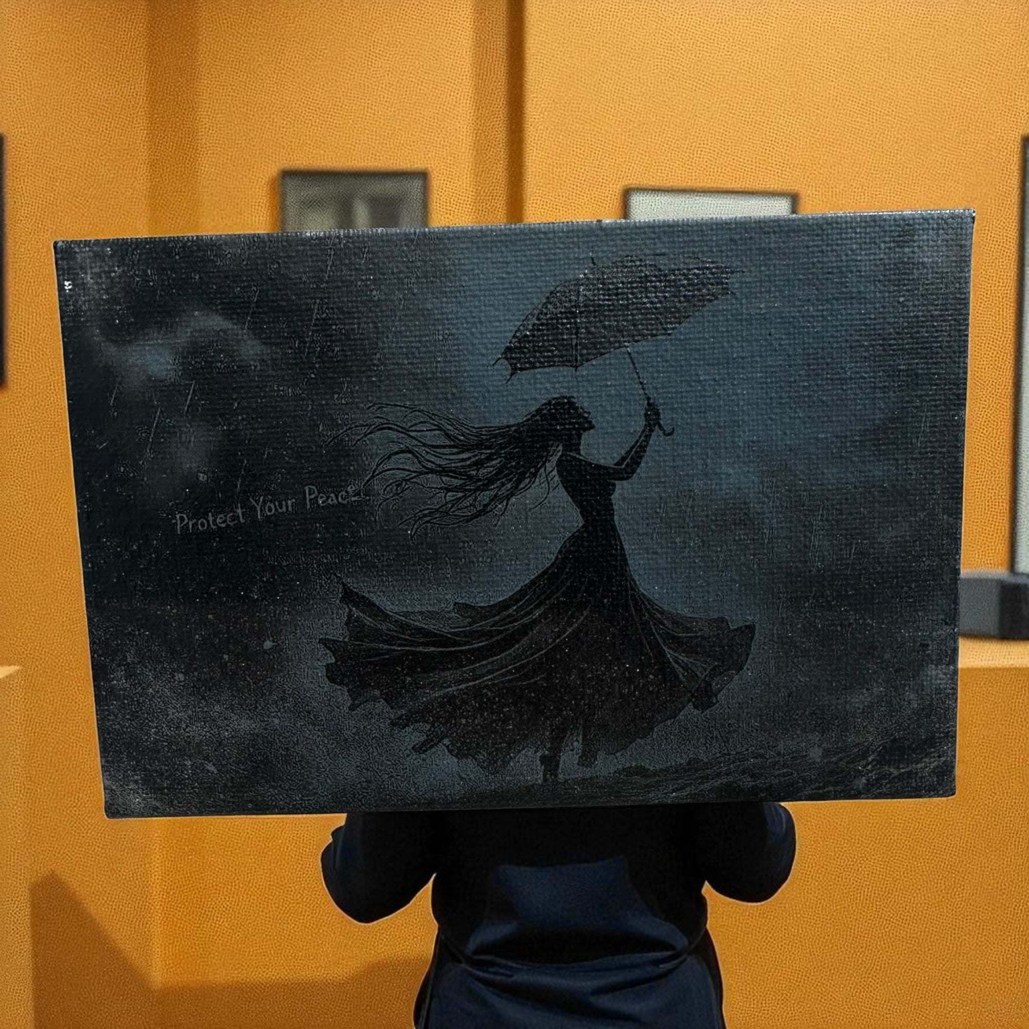 Laser-engraved 4x6 canvas art with a silhouette of a woman holding an umbrella and the phrase "Protect Your Peace"
