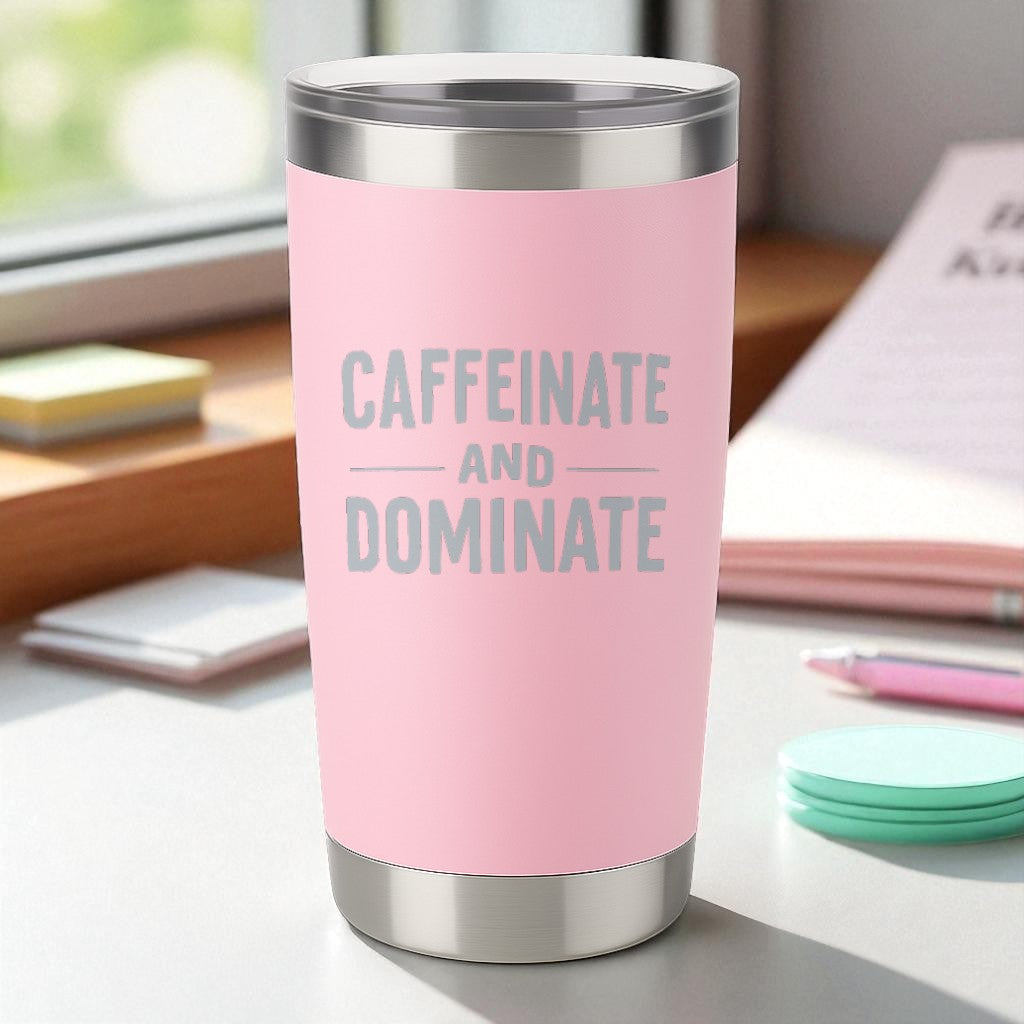 Pink 20oz stainless steel tumbler with "Caffeinate and Dominate" laser-engraved text and clear lid.
