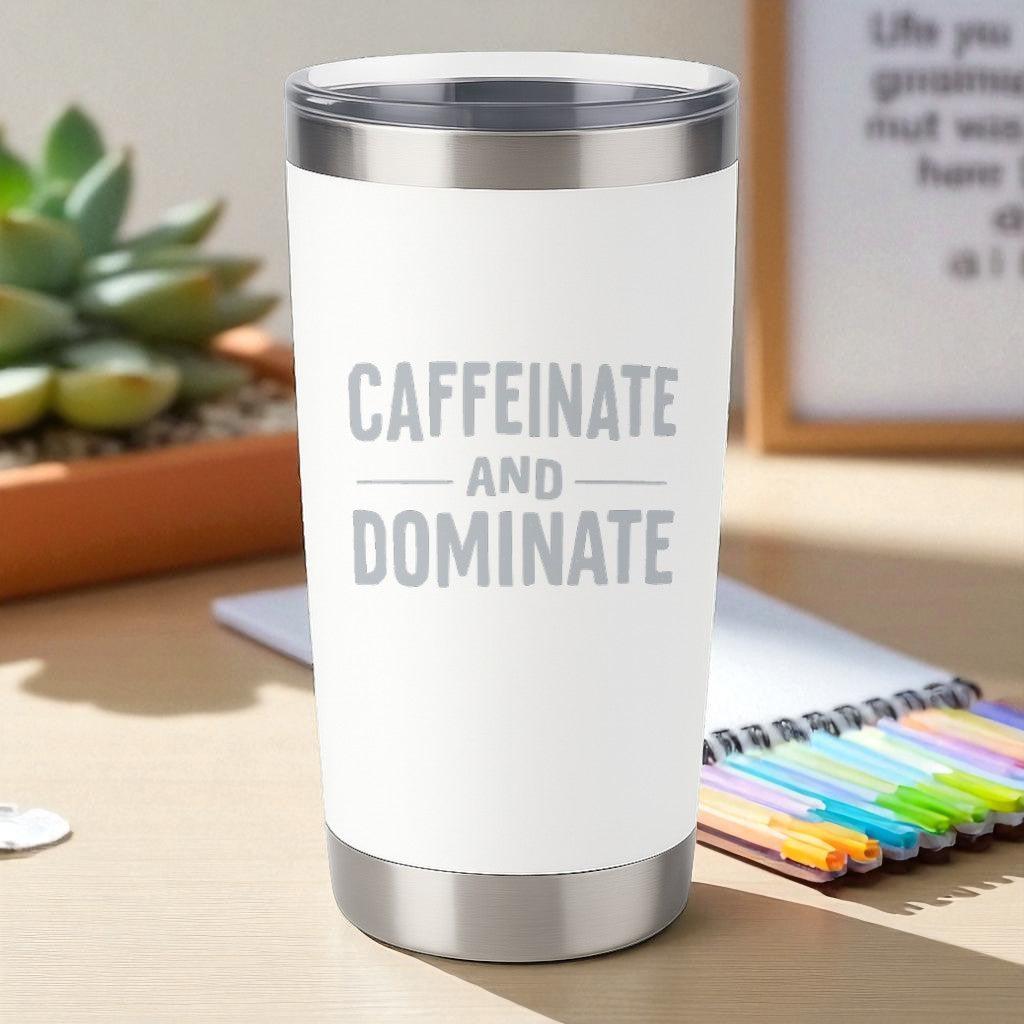 20oz white stainless steel tumbler with laser-engraved "Caffeinate and Dominate" text and clear lid on desk.