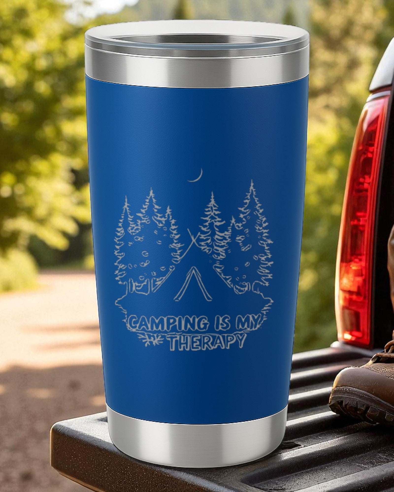 Blue tumbler with engraved "Camping is My Therapy" design featuring trees, a tent, and a crescent moon for outdoor lovers.
