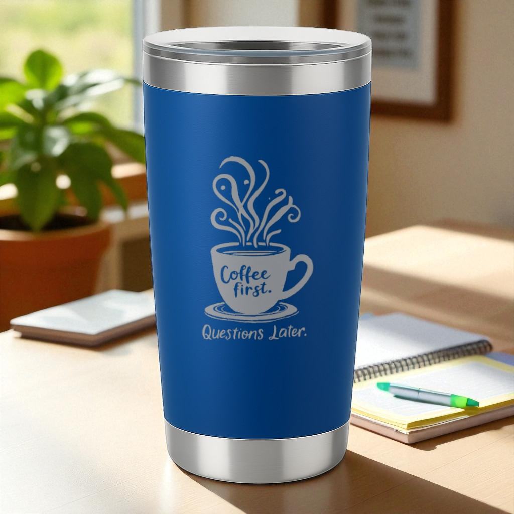 Blue coffee tumbler with "Coffee First. Questions Later" engraved text and steaming cup design on office desk