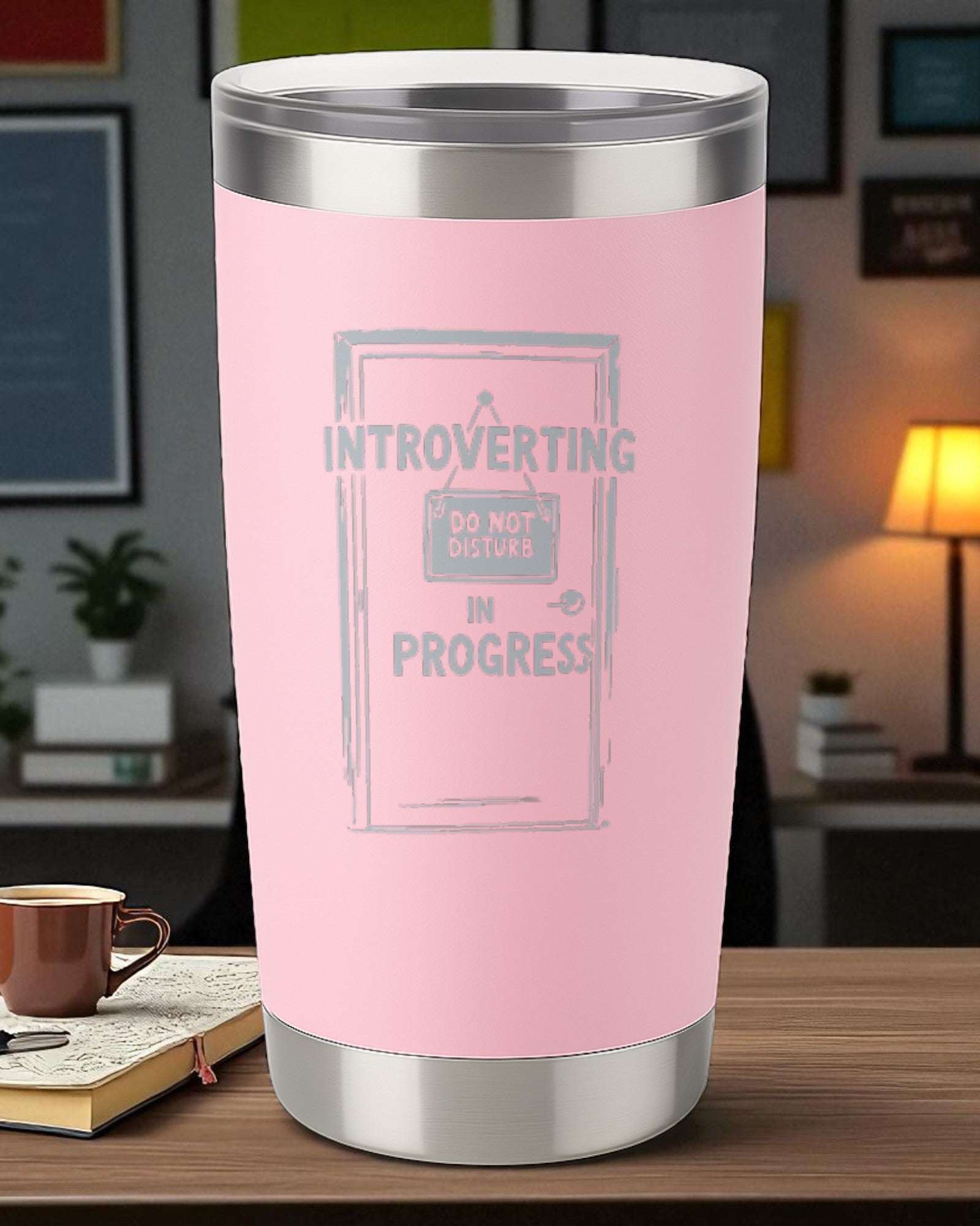 20oz pink engraved stainless steel tumbler with "Introverting in Progress" design and clear lid on wooden table
