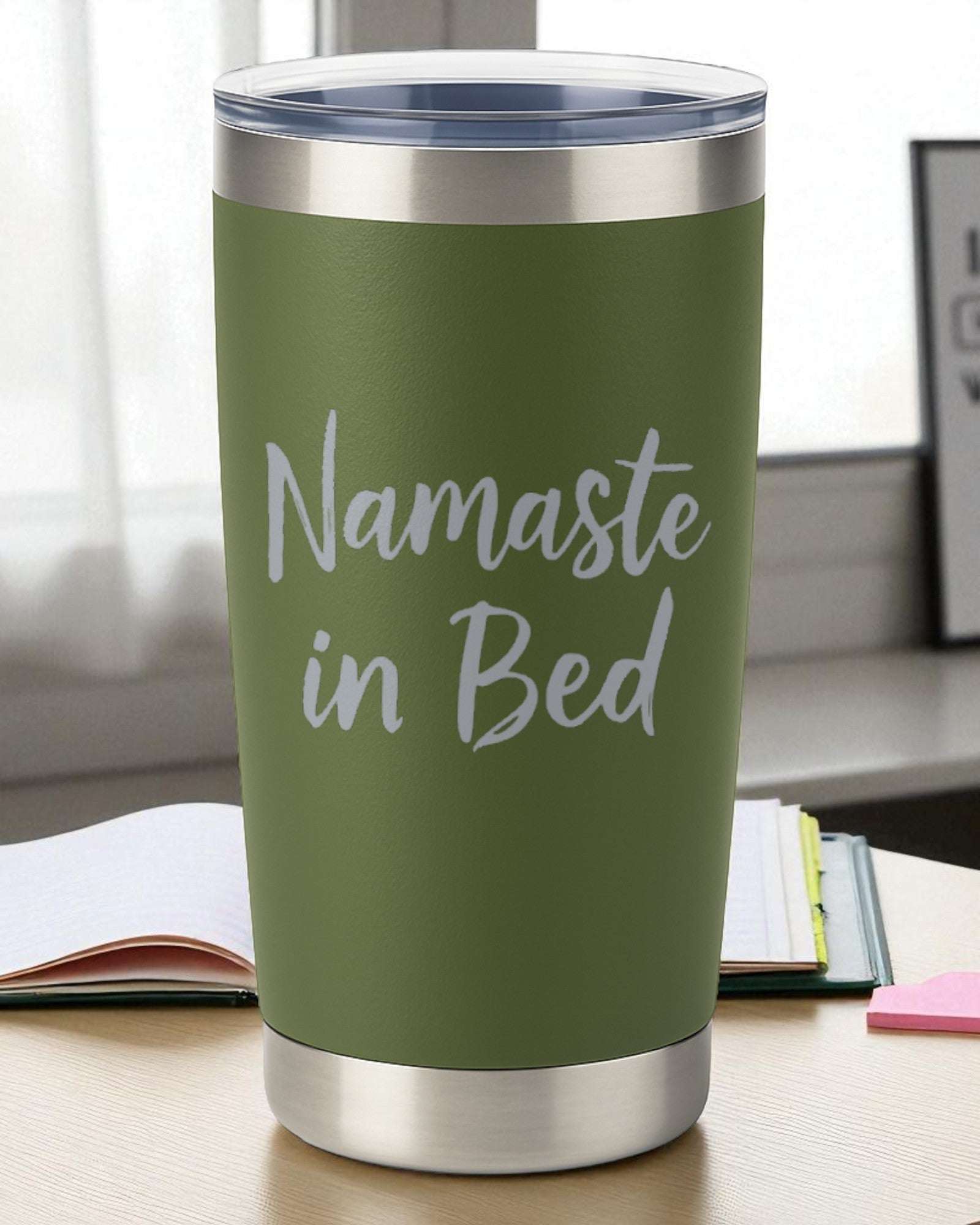 Green stainless steel tumbler with "Namaste in Bed" text for cozy morning relaxation and self-care