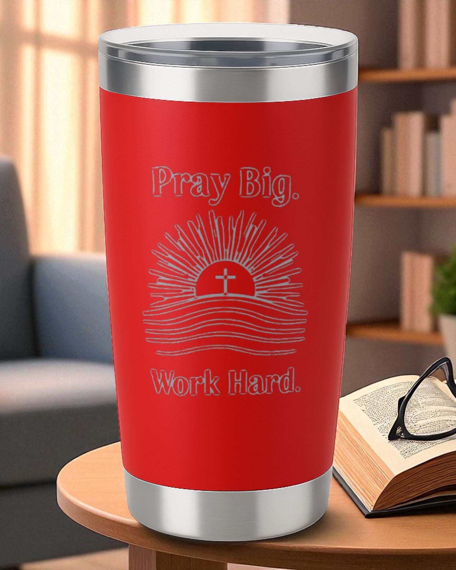 Red Faith Hustle Tumbler with "Pray Big. Work Hard." motivational design and cross graphic on table next to open book and glasses