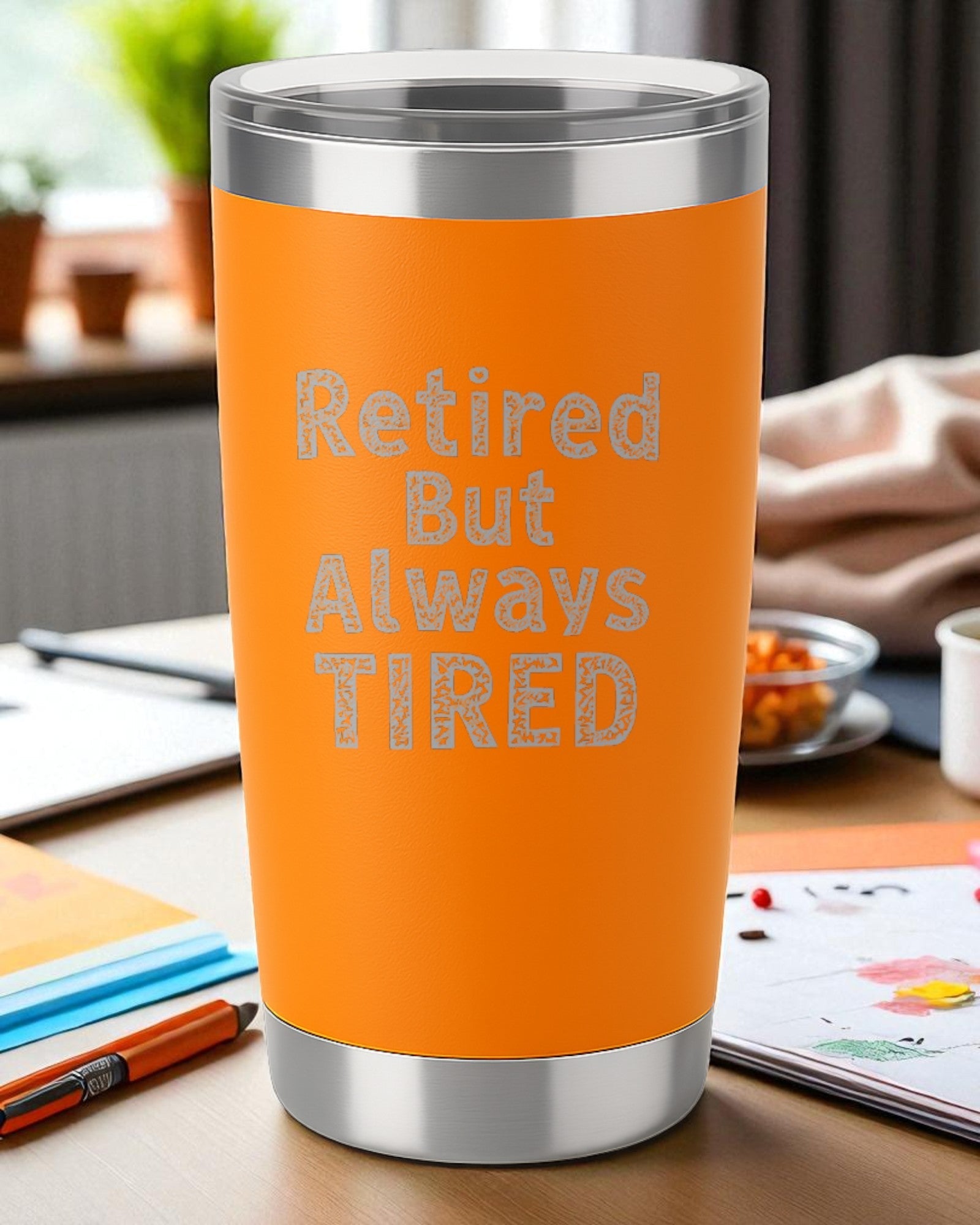 Orange 20oz stainless steel tumbler with "Retired But Always Tired" engraved text and clear lid.