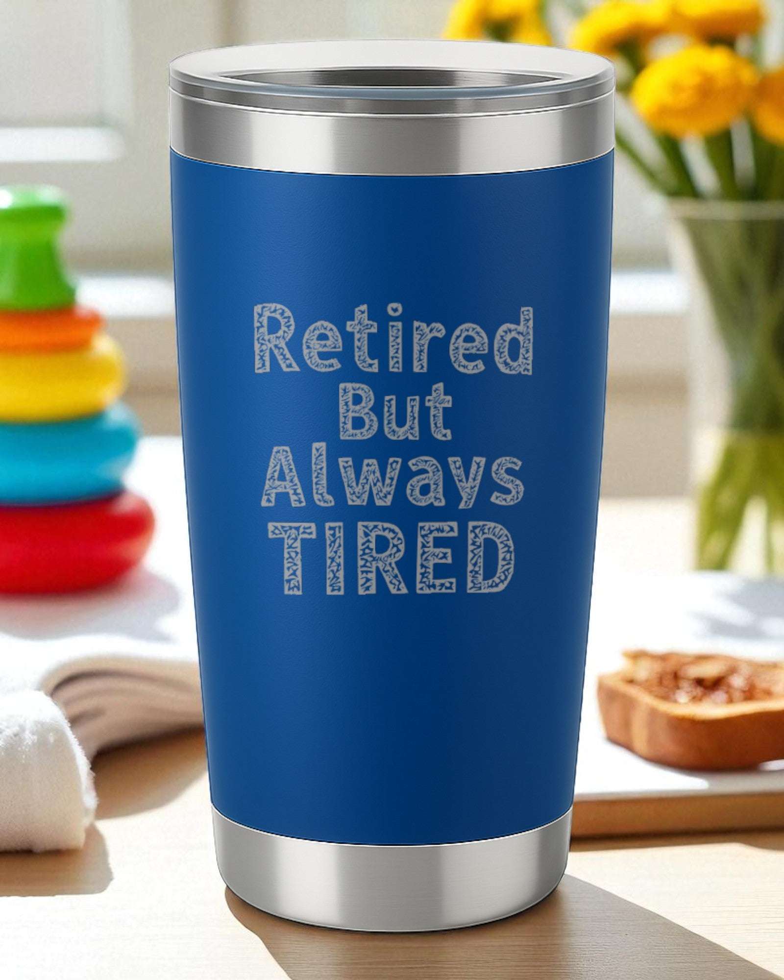 Blue 20oz stainless steel tumbler engraved with "Retired But Always Tired" text, double-wall insulated with clear lid.