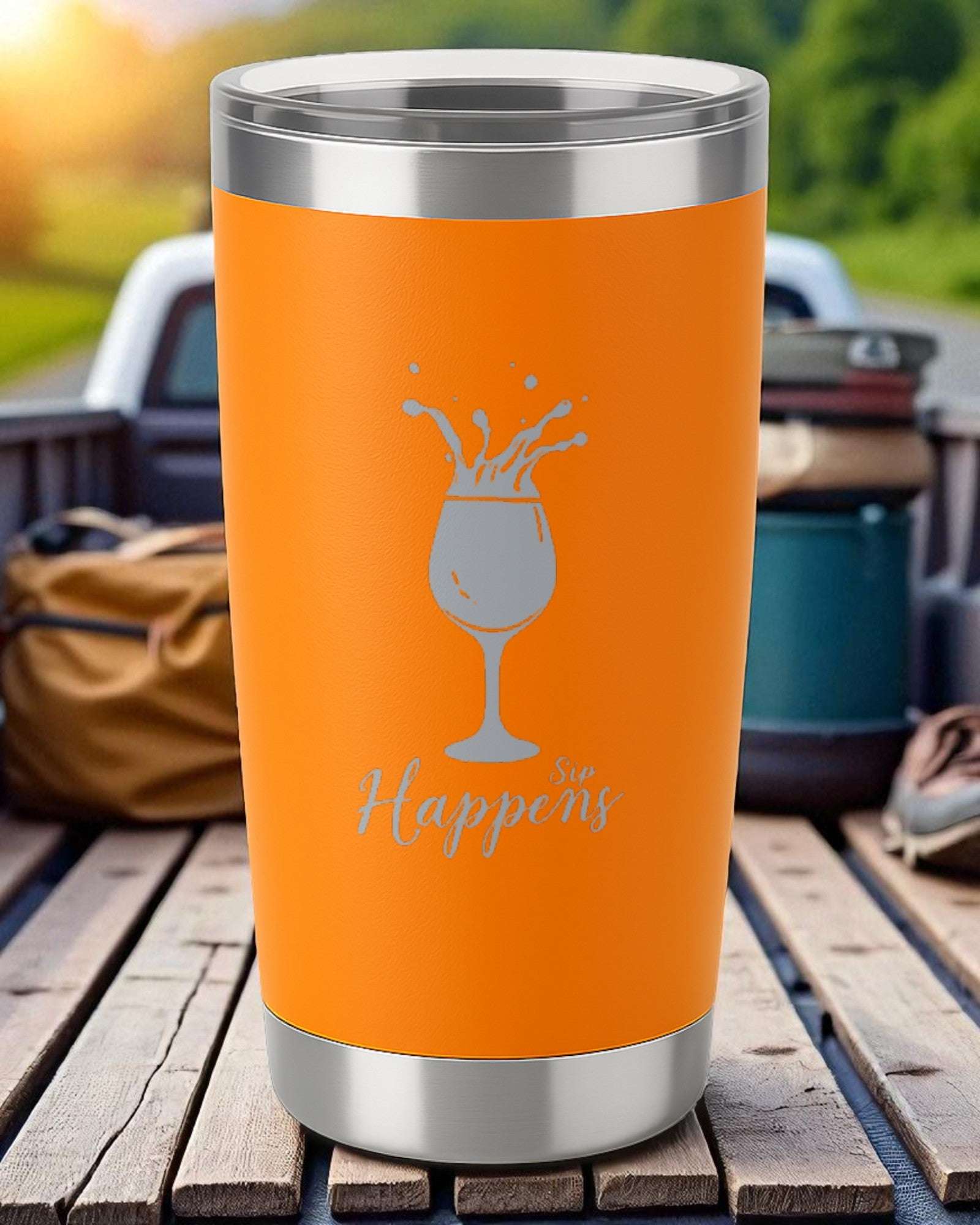 Orange 20oz insulated tumbler with "Sip Happens" laser-engraved design and clear slide lid.