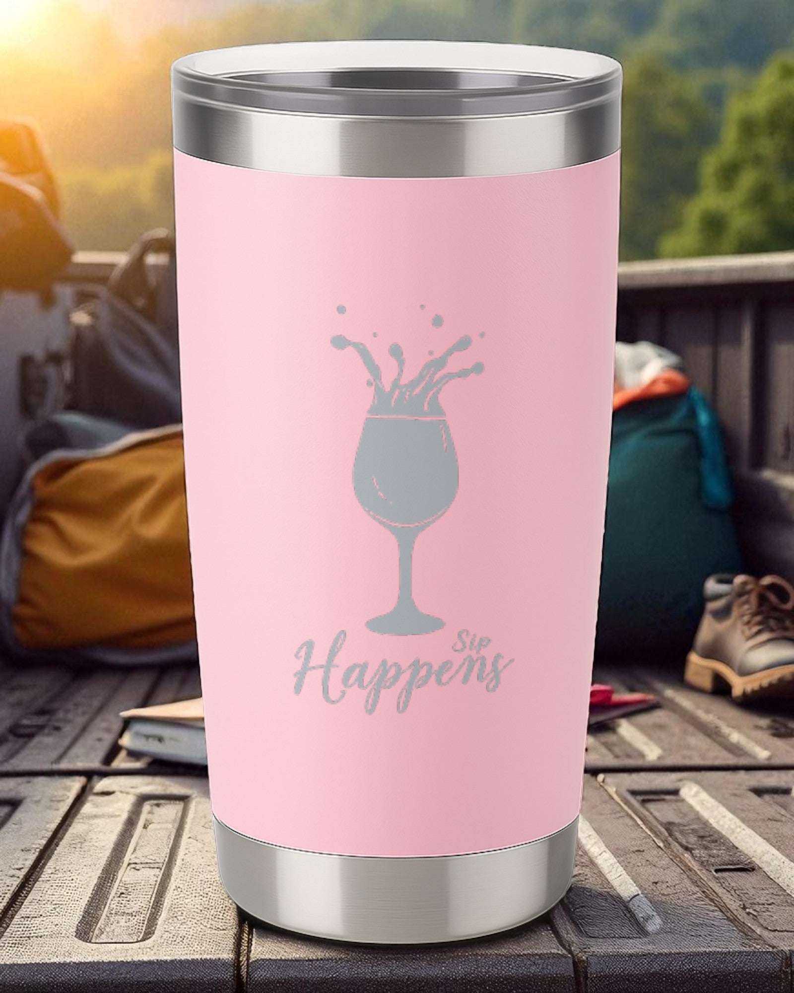 Pink 20oz insulated tumbler with silver lid and engraving of a wine glass splash and "Sip Happens" text
