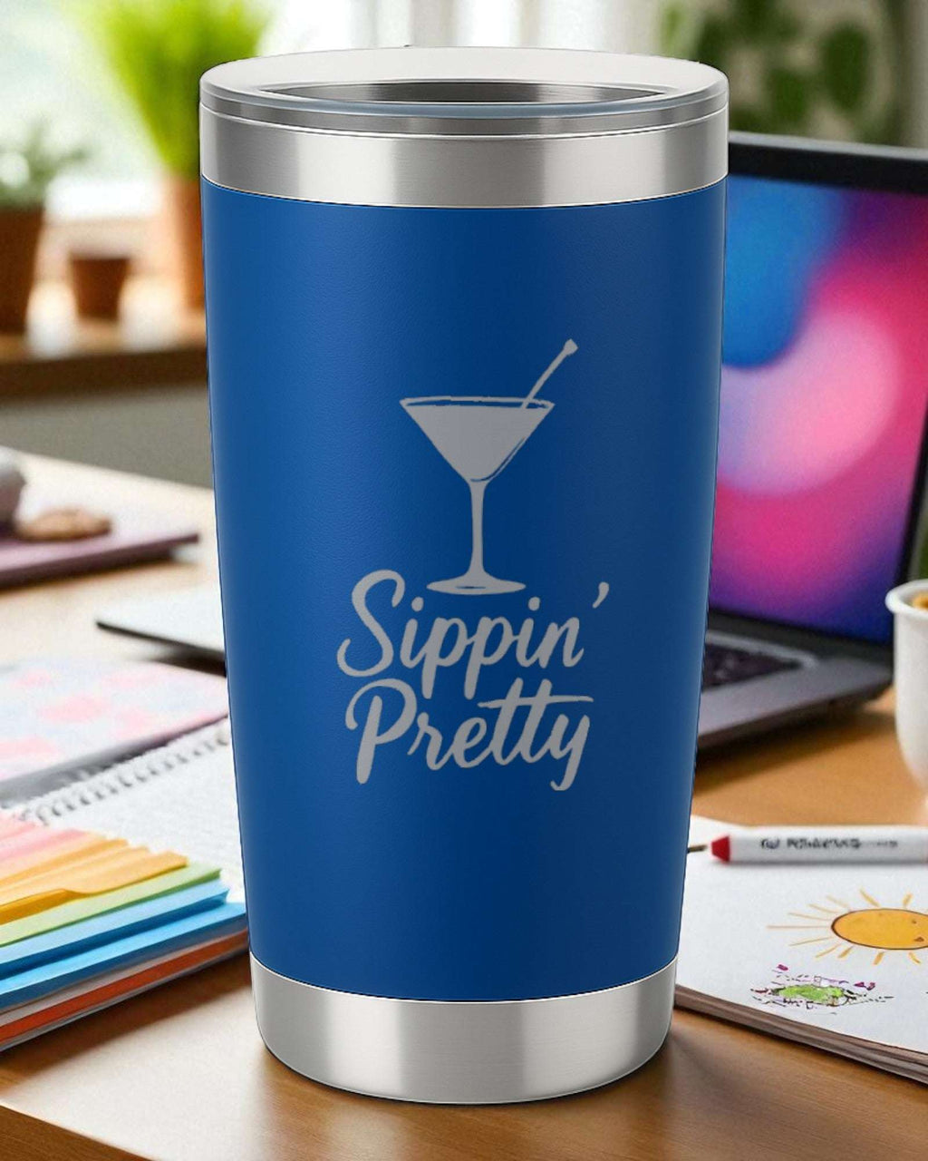 Blue 20oz stainless steel tumbler engraved with "Sippin’ Pretty" and a cocktail glass design, featuring a clear lid and double-walled insulation.