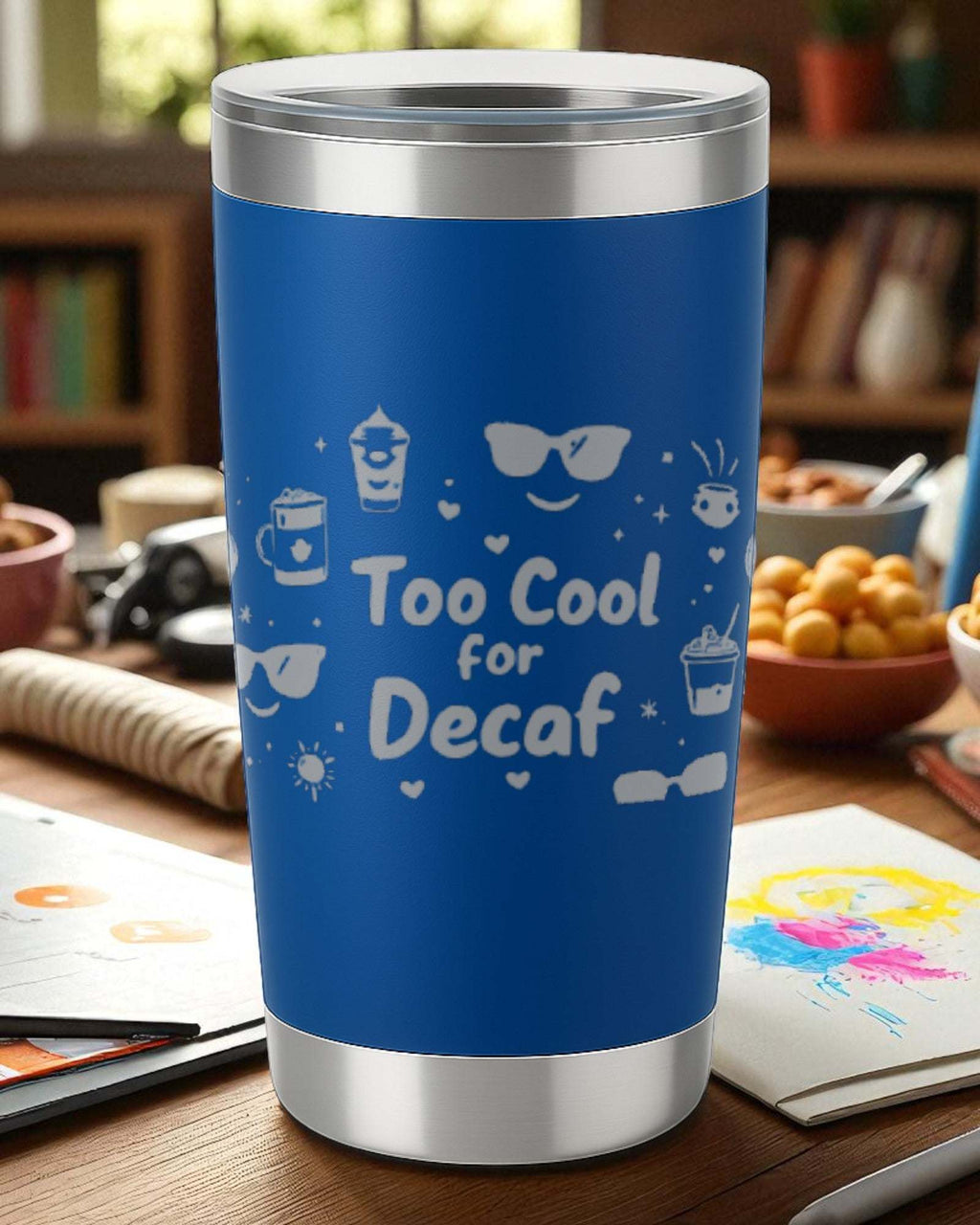 Blue 20oz stainless steel insulated tumbler with laser-engraved "Too Cool for Decaf" design and clear lid.