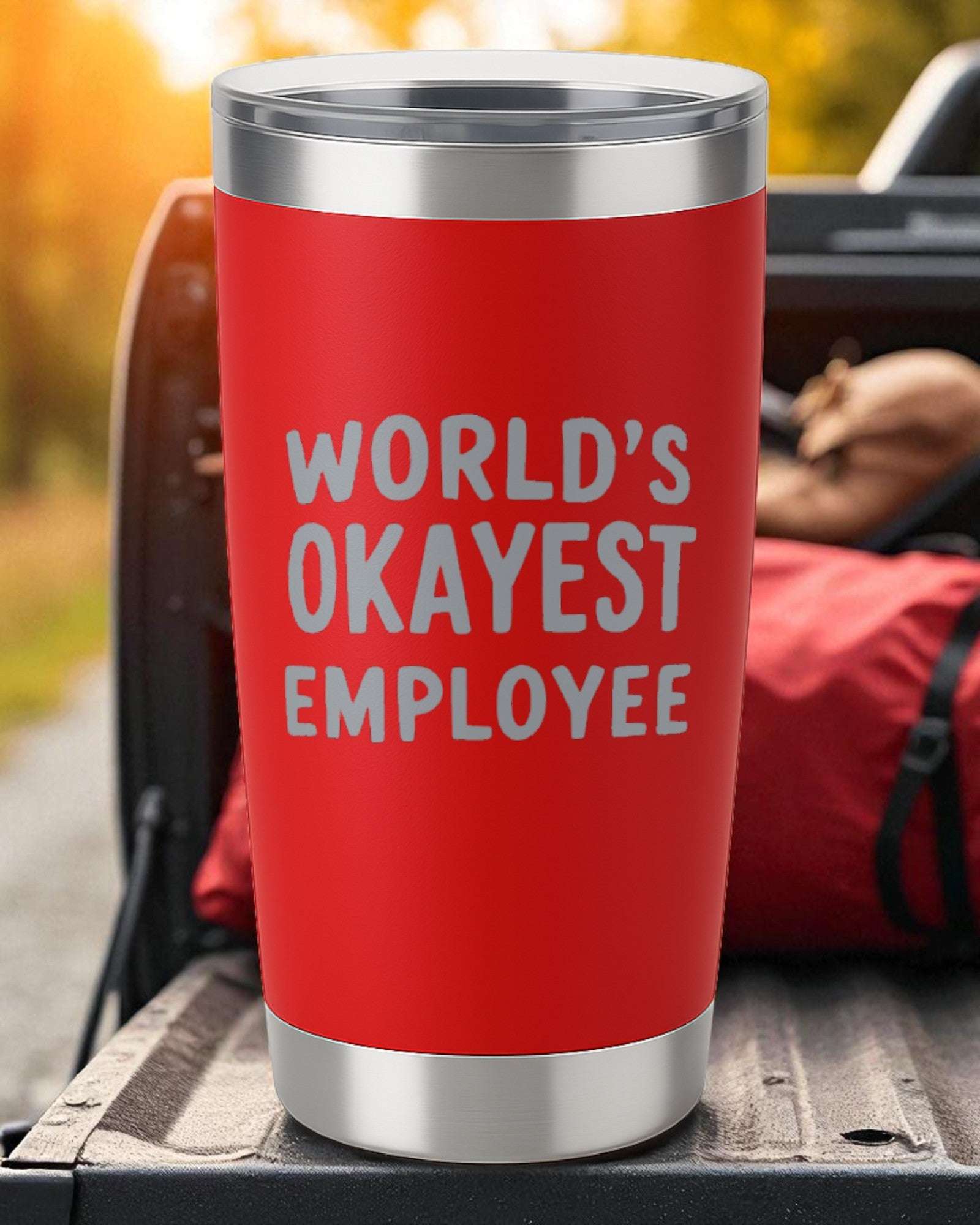 Red 20oz stainless steel tumbler with "World's Okayest Employee" laser-engraved text and double-wall insulation.