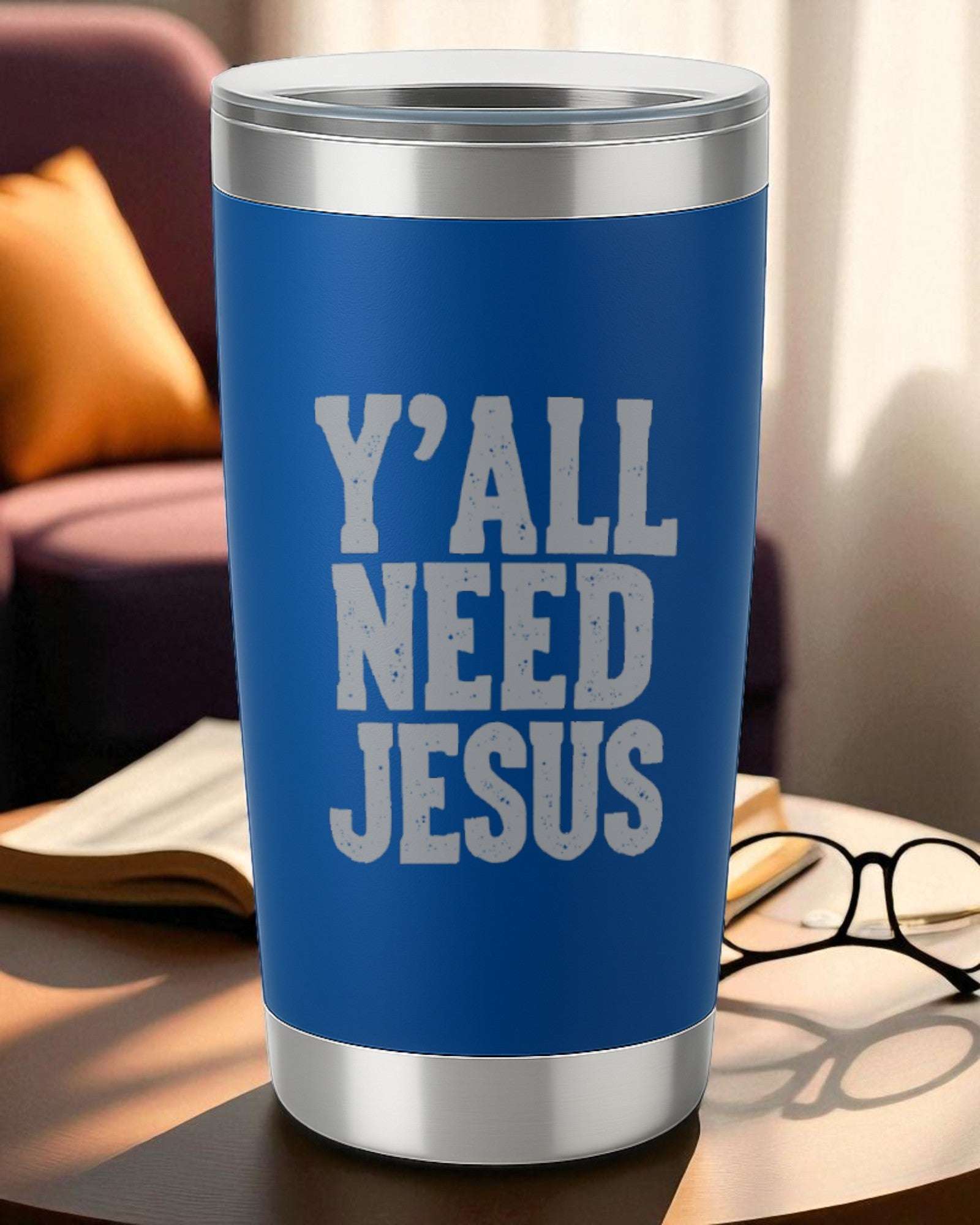 20oz blue stainless steel tumbler with engraved "Y'all Need Jesus" text and clear lid on a table