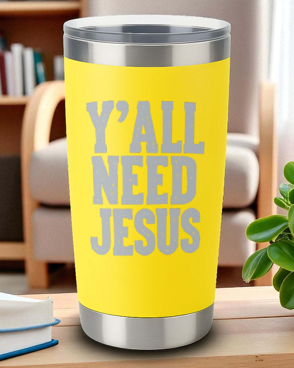 Yellow 20oz stainless steel tumbler with engraved "Y'all Need Jesus" text and clear lid on wooden table.