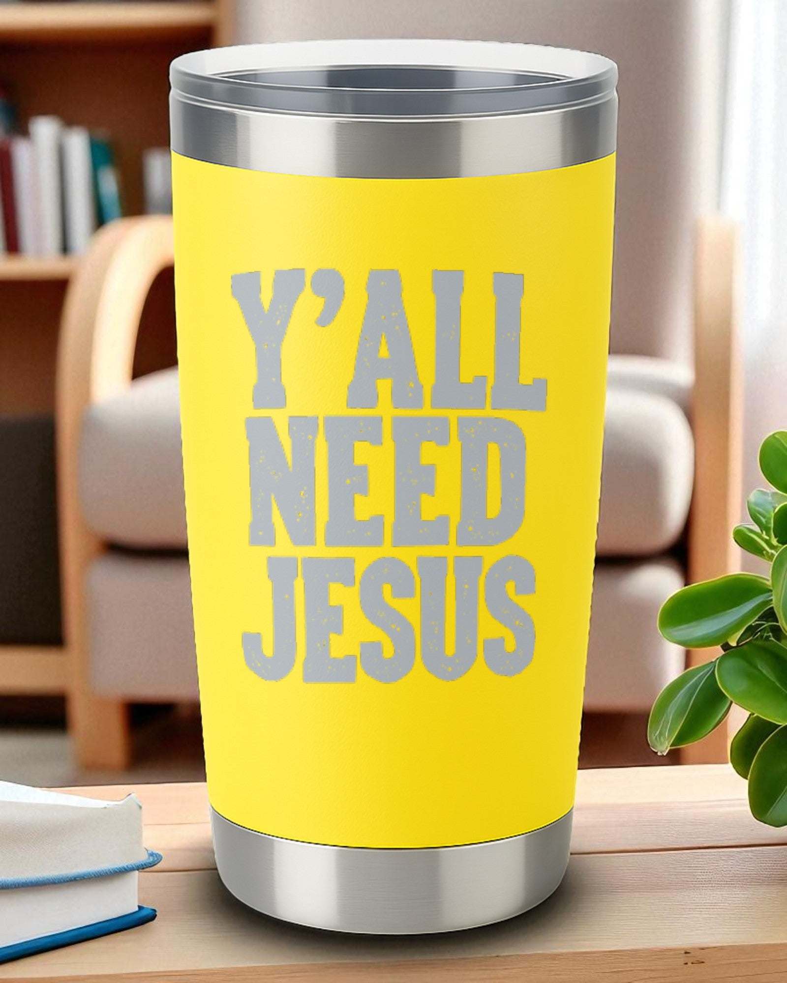 Yellow 20oz stainless steel tumbler with engraved "Y'all Need Jesus" text and clear lid on wooden table.